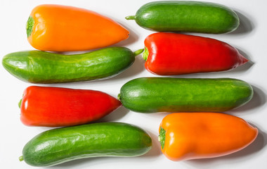 Colorful pepper and green cucumber on white background, horizont