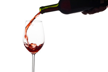 Rotwein wird in ein Weinglas eingegossen