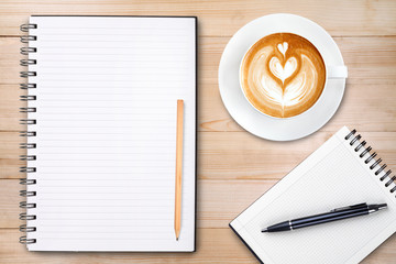 An open blank notebook with pencil and a cup of coffee on wooden