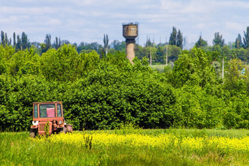 Fototapeta premium old tractor on a meadow, rural landscape