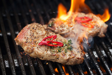 pork steak on bbq grill with flame