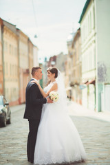 Naklejka premium Happy bride and groom dancing on a street