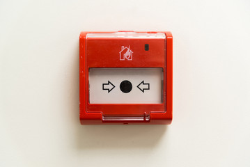 Red fire button on light wall