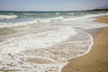 Fototapeta na wymiar Waves, white sand beach and blue sky