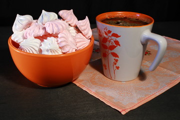 Meringue Cookies with nuts and cup of coffee on dark wooden background, top view