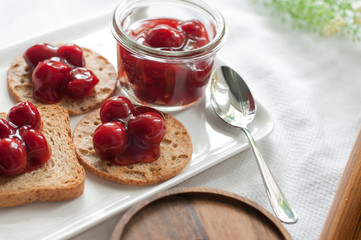 cherry topping dessert on cracker bread white plate