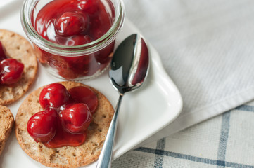 cherry topping dessert on cracker bread white plate