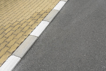 Border sidewalk and the asphalt road.
