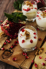Obraz na płótnie Canvas yogurt dessert with walnuts and pomegranate selective focus