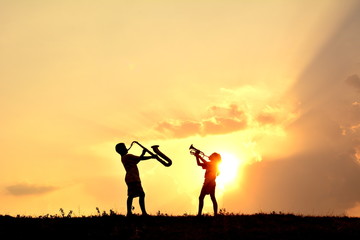 Silhouette children playing musical at sky sunset .warm tone