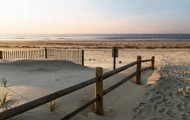 Sand dunes, a wooden fence on a background of blue ocean Ocean city NJ