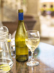 Bottle of Half Empty White Wine with a Glass Half Full