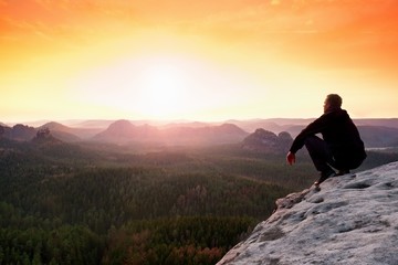 Man enjoing watching orange daybreak in mountains