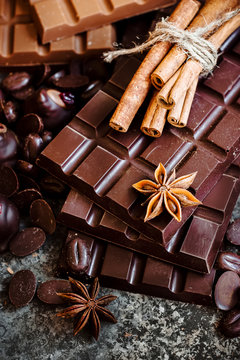 Delicious chocolates and spices on a dark background.