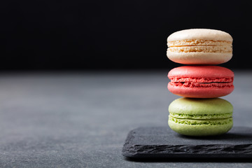Fototapeta na wymiar Colorful French Macarons on the slate stone background Copy space