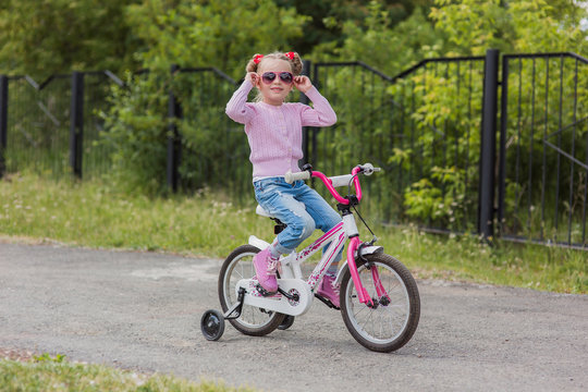 girl rides a bicycle on a warm summer track