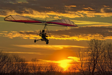 Hang glider fly in the sunset