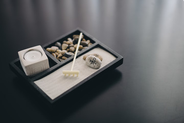 Zen garden with sand, rake, stones, and candle