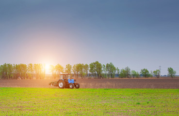 In the morning at sunrise tractor rides to plow a field