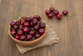 Sweet cherries with  on brown wooden background