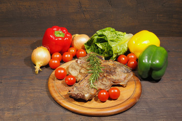 Grilled T bone steak with rosemary tomatoes, paprika onions and