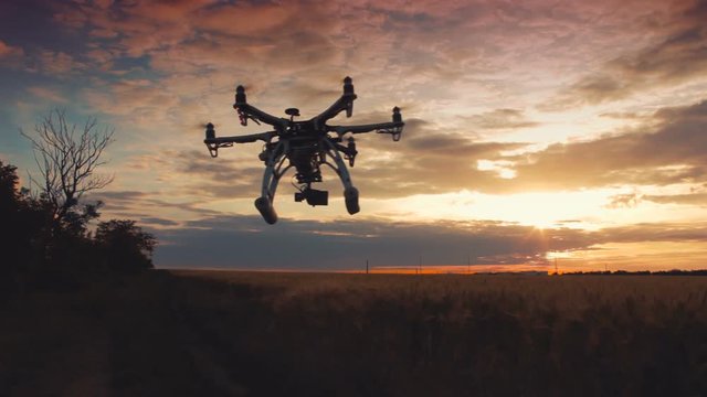 Custom drone hexacopter flying in the sky at sunset