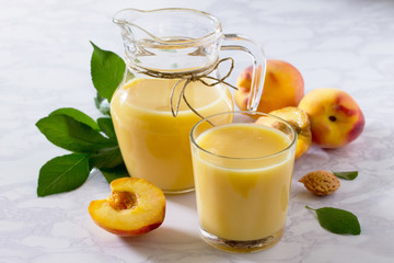 Milk cocktail of peach, mixed with kefir yogurt on a gray stone