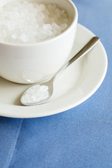 cup of refined sugar on the white- blue background