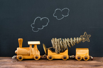 Christmas concept, old wooden toy train with Christmas tree, steam on the chalkboard background