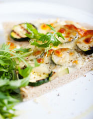 Whole Grain pizza with vegetables and fresh salad on a white plate Selective focus