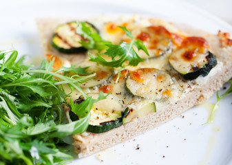 Whole Grain pizza with vegetables and fresh salad on a white plate Selective focus