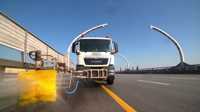 city road cleaning machine clearing road barriers in modern highway with water jet and brush