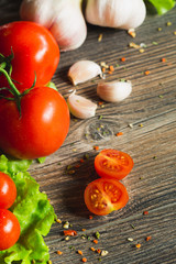 Fresh tomatoes with salad leaves on the table. Background.
