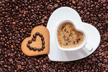 Obrazy na Szkle  Kubek w kształcie serca i ciastko na tle ziaren kawy