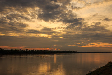 Fototapeta na wymiar Sun and clouds over river
