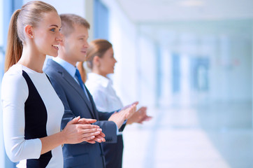 Smiling business people applauding a good presentation in the office