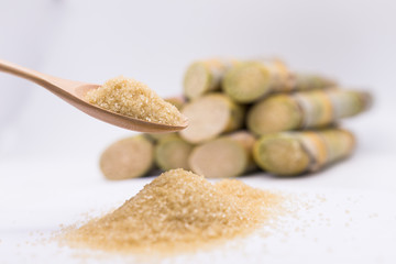 Close up brown Sugar in spoon  on sugarcane blur background