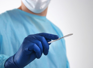 Man surgeon holds a scalpel