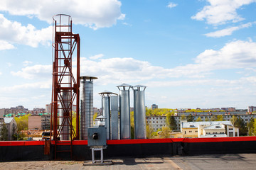 shopping center ventilation system. ventilation pipe on the background of summer city and blue sky with clouds. copy space for your text