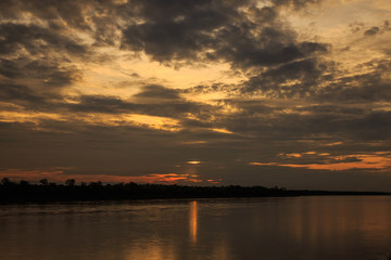 Fototapeta na wymiar Sun and clouds over river