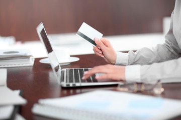Fototapeta premium Close up of business woman hands using credit card and laptop computer