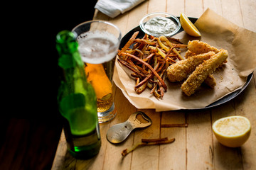 Close-up of fish and chips served with beer
