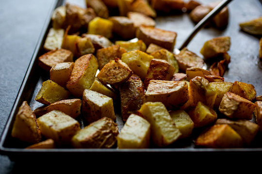 Cubed roasted potatoes on baking tray