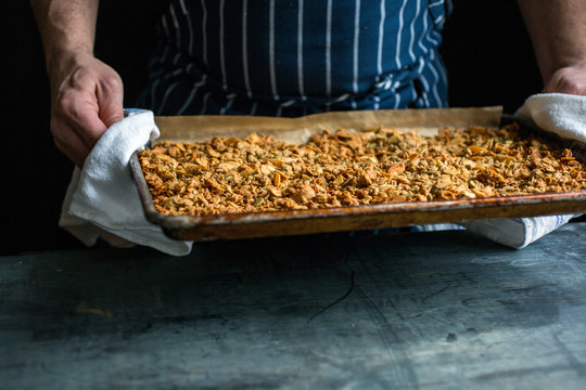Person holding tray of baked granola