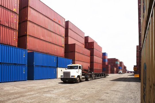 View of stacks of cargo containers and trucks
