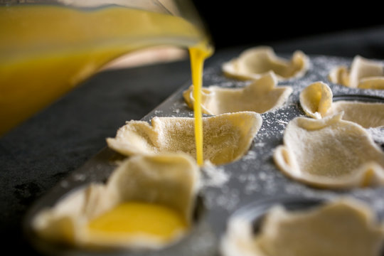 Pouring egg mixture into tart cases