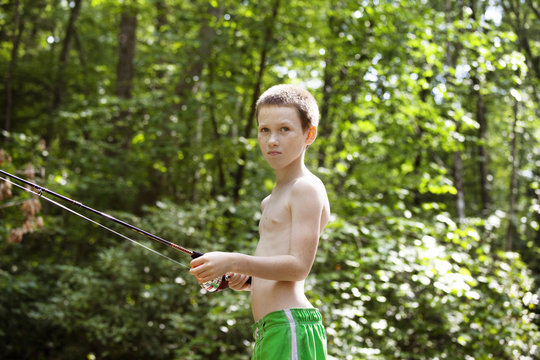 Boy (10-11) fishing in forest