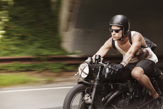 Confident Man Riding Motorcycle On Road