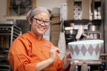 Baker decorating icing on cake