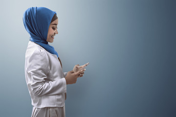Muslim woman typing on cellphone